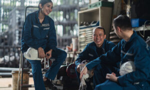 A group of diverse Asian factory workers having a hearty conversation while taking a break